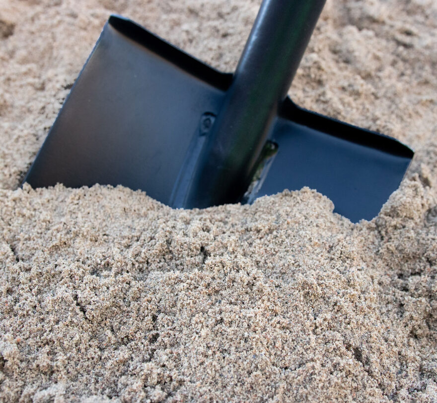 Sand 0/4 i närbild med spade